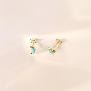Detail of asymmetric gold flower and moon stud earrings with light blue turquoise inlay