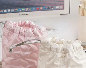 Detail of pink heart quilted and white floral drawstring PU bags for cosmetics