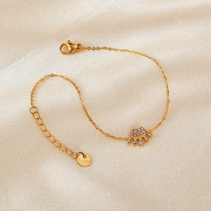 Detailed macro view of gold crown charm and S.Steel tag on stainless steel bracelet