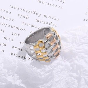 Macro detail of tricolor mesh woven stainless steel ring with hollow weave pattern