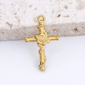 Macro shot of a vintage gold-plated stainless steel cross pendant with rose detail