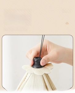 Detail of beige insulated food cover showing umbrella-style folding mechanism for storage