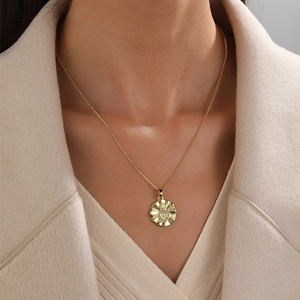 Golden heart pendant necklace with zircon stone on model with cream background