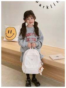 Detailed view of white nylon kids backpack with cat ear design on a girl model