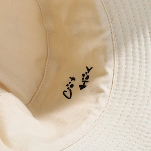 Detail of cute cat embroidery inside the cream canvas bucket hat with neat brim stitching