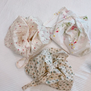 Three floral cotton tote bags with artistic ink patterns on white quilted background