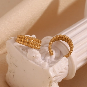 Vue détaillée du ear cuff à trois rangées de perles dorées sur un socle classique