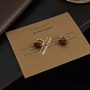 Boucles d'oreilles dorées rétro avec pendentif goutte d'huile rouge sur papier kraft