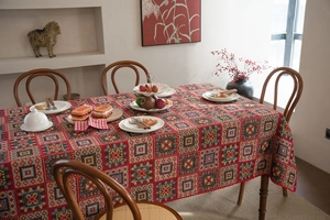 Detailed view of red festive tablecloth with geometric patterns on a wooden dining table