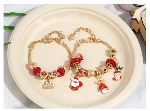 Close-up of gold Christmas beaded bracelets with Santa Claus and reindeer charms