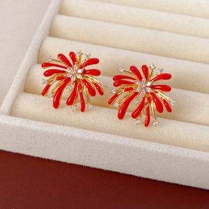 Détail macro de boucles d'oreilles feu d'artifice rouge avec zircons sur présentoir blanc