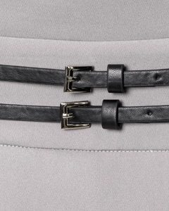 Detail of grey pleated dress featuring double thin black leather belts with silver buckles