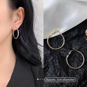 Detail showing 3cm diameter of oversized golden hoop earrings on model with measurements