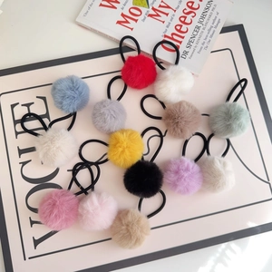 Flat lay of colorful plush faux fur pompom elastic hair ties on a fashion magazine