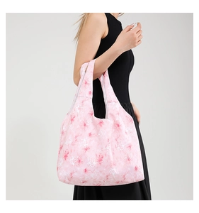 Detailed shot of pink floral tote bag with marble pattern on a black dress model
