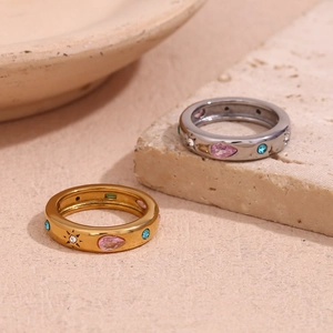 Close-up of gold and silver rings with colorful zircon gems and engraved star patterns