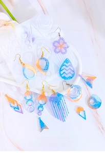 Detail of geometric silicone molds for resin earrings with orange and blue glitter samples