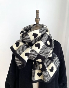 Close-up of heart pattern and soft knit texture on black and white checkered scarf