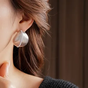 Minimalist silver needle water drop earrings with pearls on an elegant female model