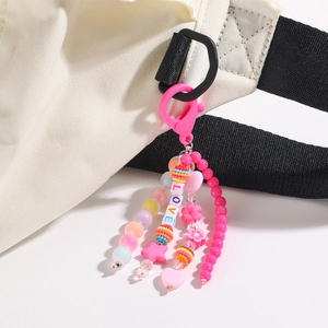 Détail d'un porte-clés en perles roses avec lettres LOVE et cœurs sur un sac en toile