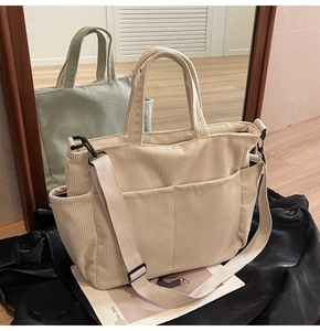 Detail of cream corduroy crossbody tote bag showing front pockets and velvet texture