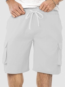 Detail of white cargo shorts featuring cotton-linen texture and drawstring waistband