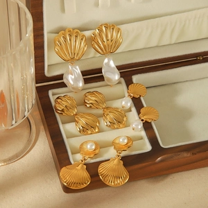 French style 18k gold shell and pearl earrings set in a wooden jewelry box