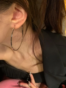 Close-up of oversized silver hoop earring worn on ear showing stylish minimalist design