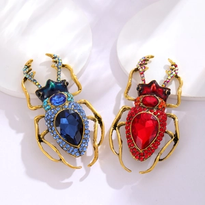 Punk style beetle brooches with blue and red rhinestones on a gold metal base