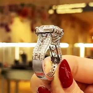 Luxury emerald cut zircon wedding ring with pavé diamond band on female hand