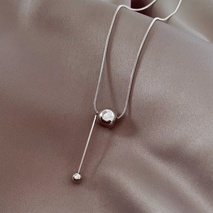 Macro view of silver titanium steel snake chain with a polished round bead pendant