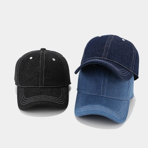 Detailed view of three denim baseball caps in black and blue with white contrast stitching