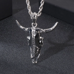 Punk style stainless steel bull skull pendant necklace with silver twist chain on black surface