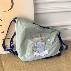 Close-up of cute elephant embroidery and nylon fabric on a green shoulder bag