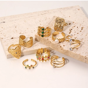 Close-up of vintage gold rings with zircon and pearls on white stone display