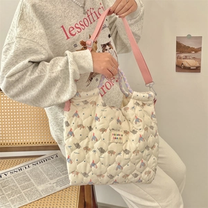 Close-up of quilted elephant print tote with adjustable strap and braided handle