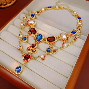 Macro shot of vintage gold earrings with rubies, sapphires and pearls in a jewelry box