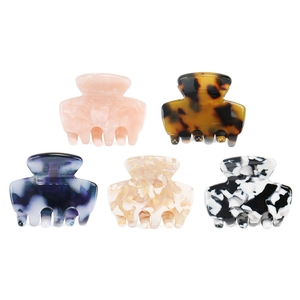 Set of five mini acetate hair claws in various marble and solid patterns on white backdrop