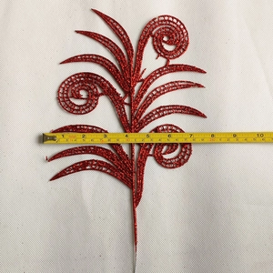 Close-up measurement of red glitter Christmas leaf showing its 10-inch width and texture