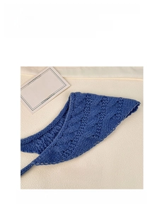 Close-up of blue crochet knit headscarf showing hollow floral pattern and soft texture