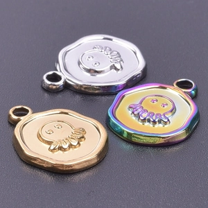 Macro shot of octopus charms in silver, gold, and rainbow finishes on dark background
