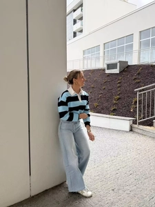 Detail of blue and black striped polo knit sweater with white contrasting collar