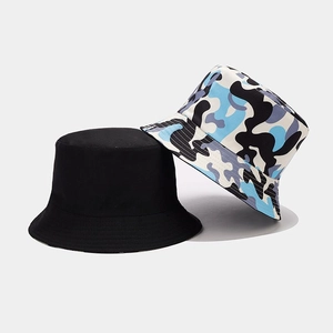 Detail of reversible camouflage and black bucket hats showing stitching and cotton fabric