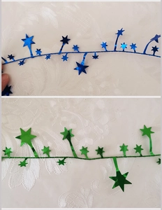 Detail of blue and green star-shaped tinsel garlands with a metallic finish for Christmas
