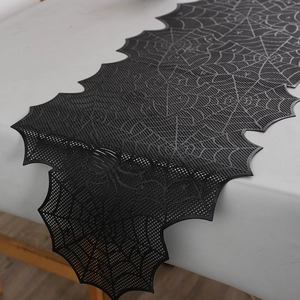 Close-up of black lace spider web table runner with detailed hollow mesh for Halloween decor