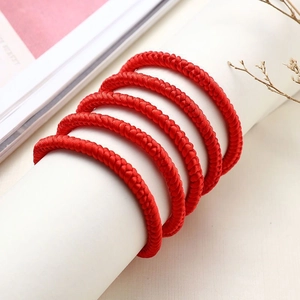 Set of six handmade red braided couple bracelets with traditional knots on display