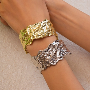 Detailed view of wide open cuff bracelet with irregular liquid metal lava texture