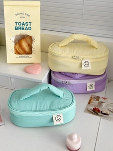 Macro shot of candy-colored nylon storage bags with top handle and smile day patch