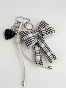 Detail van Koreaanse stijl sleutelhanger met zwart hart van hars en ruitjesstrikje