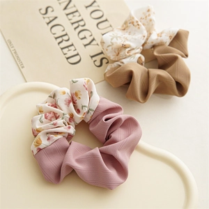 Close-up of floral and solid patchwork scrunchies on a heart-shaped display tray